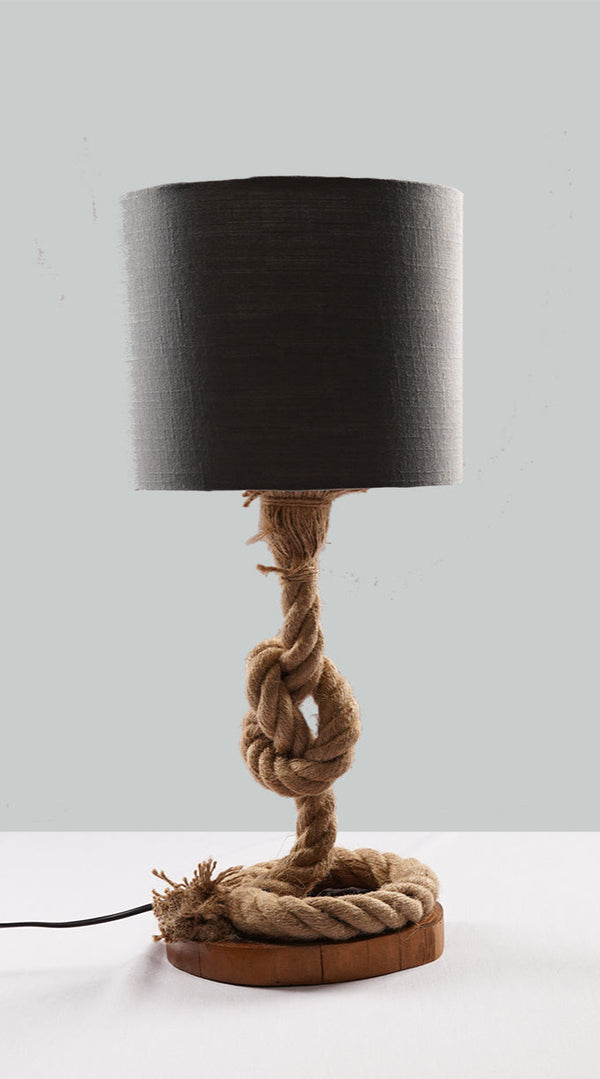 A table lamp with a grey shade, featuring a unique base made of twisted rope and a wooden element, without a lamp color, against a plain background.