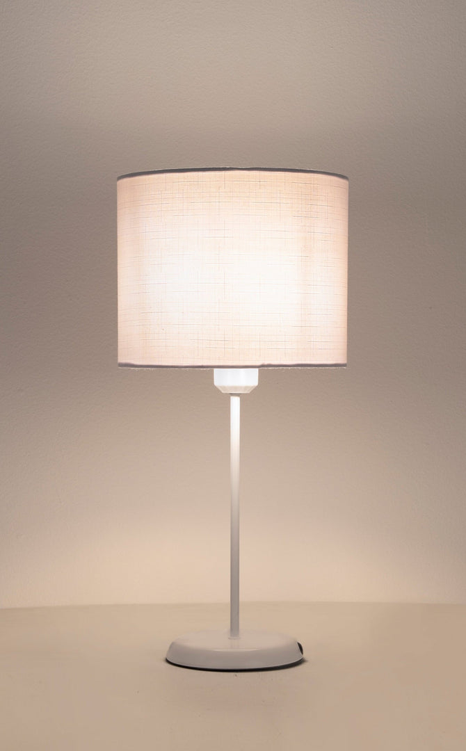 Table lamp with a beige fabric shade on a neutral background