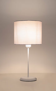 Table lamp with a beige fabric shade on a neutral background