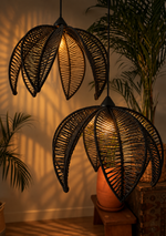 Load image into Gallery viewer, Black leaf pendant light on, warm wall reflections